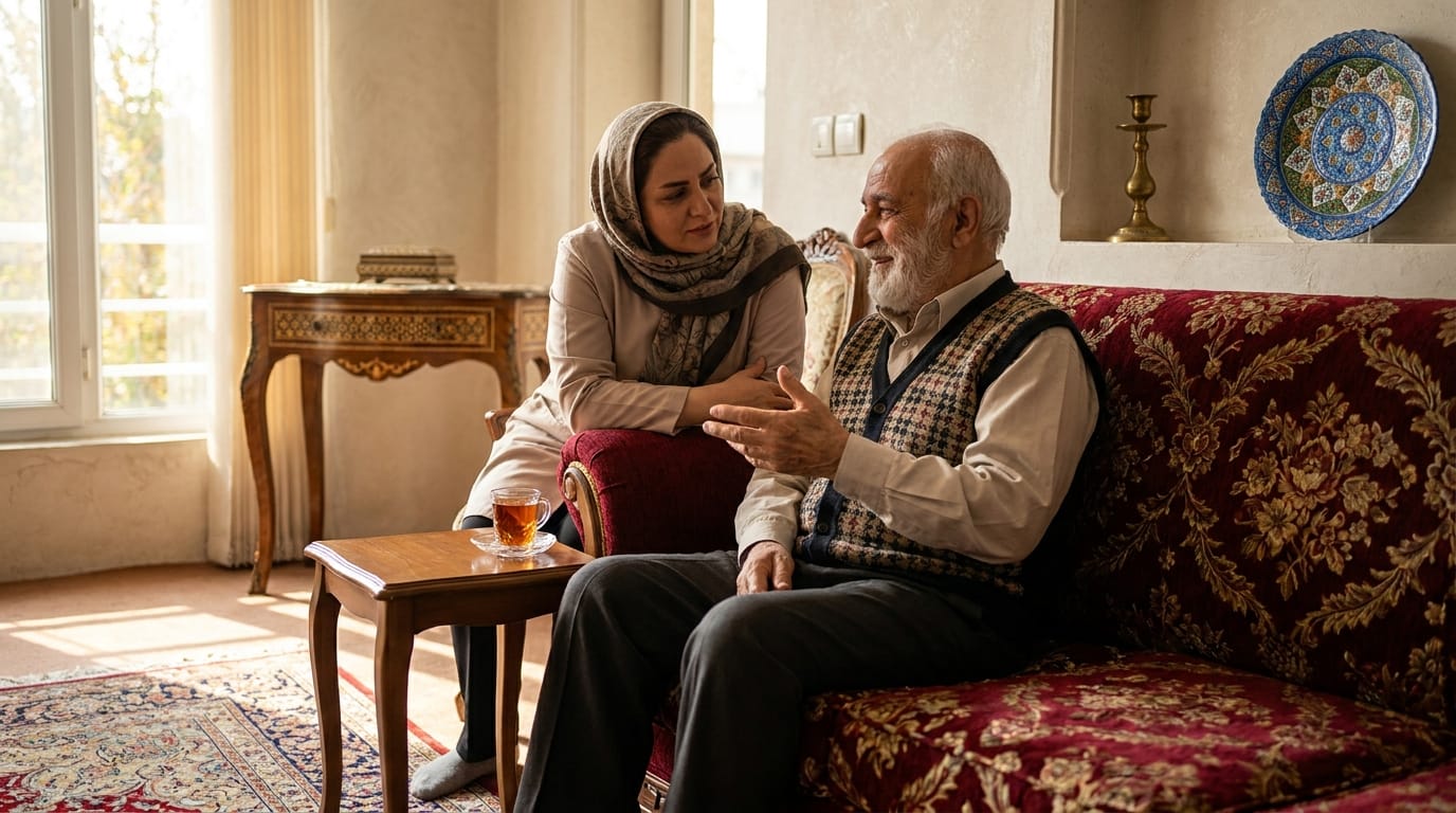 پرستار سالمند در حال نوشیدن چای و گفتوگوی صمیمانه با سالمند روی مبل خانه